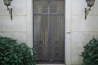 Jardin verdoyant avec pelouse bien entretenue, arbres et arbustes sous un ciel bleu dégagé.