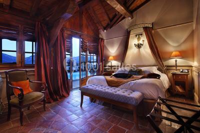 Vue aérienne d'un domaine entouré de verdure, avec des montagnes en arrière-plan sous un ciel dégagé.