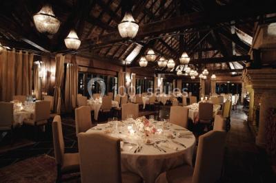 Vue aérienne d'un domaine entouré de verdure, avec des montagnes en arrière-plan sous un ciel dégagé.