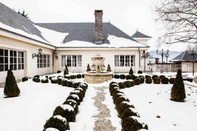Vue aérienne d'un domaine entouré de verdure, avec des montagnes en arrière-plan sous un ciel dégagé.