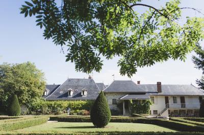 Vue aérienne d'un domaine entouré de verdure, avec des montagnes en arrière-plan sous un ciel dégagé.