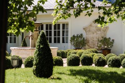 Vue aérienne d'un domaine entouré de verdure, avec des montagnes en arrière-plan sous un ciel dégagé.