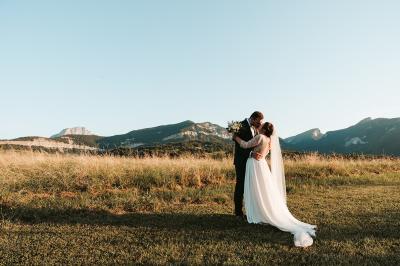 Vue aérienne d'un domaine entouré de verdure, avec des montagnes en arrière-plan sous un ciel dégagé.