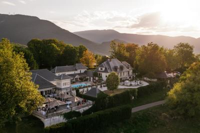 Intérieur d'un sauna en bois en forme de tonneau avec vue sur un paysage verdoyant et des montagnes au loin.