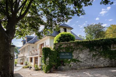 Intérieur d'un sauna en bois en forme de tonneau avec vue sur un paysage verdoyant et des montagnes au loin.
