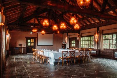 Intérieur d'un sauna en bois en forme de tonneau avec vue sur un paysage verdoyant et des montagnes au loin.