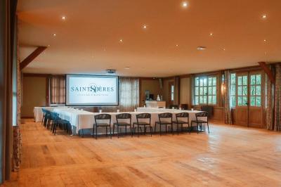 Intérieur d'un sauna en bois en forme de tonneau avec vue sur un paysage verdoyant et des montagnes au loin.