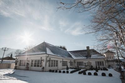 Intérieur d'un sauna en bois en forme de tonneau avec vue sur un paysage verdoyant et des montagnes au loin.