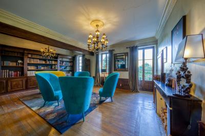 Intérieur d'un sauna en bois en forme de tonneau avec vue sur un paysage verdoyant et des montagnes au loin.