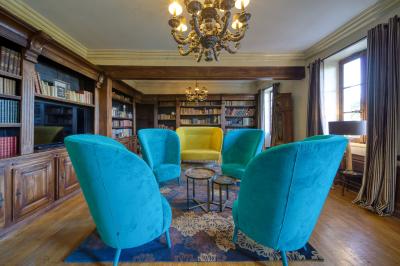 Intérieur d'un sauna en bois en forme de tonneau avec vue sur un paysage verdoyant et des montagnes au loin.