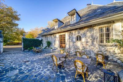 Intérieur d'un sauna en bois en forme de tonneau avec vue sur un paysage verdoyant et des montagnes au loin.