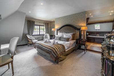 Intérieur d'un sauna en bois en forme de tonneau avec vue sur un paysage verdoyant et des montagnes au loin.