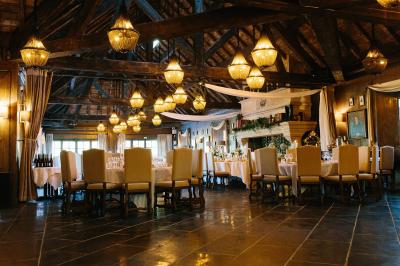 Intérieur d'un sauna en bois en forme de tonneau avec vue sur un paysage verdoyant et des montagnes au loin.