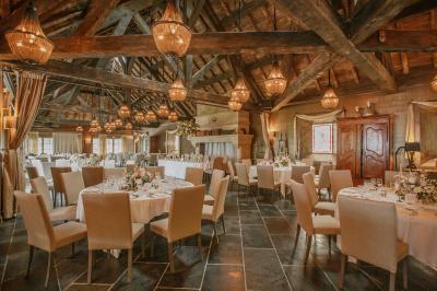 Intérieur d'un sauna en bois en forme de tonneau avec vue sur un paysage verdoyant et des montagnes au loin.
