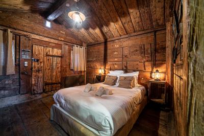 Intérieur d'un sauna en bois en forme de tonneau avec vue sur un paysage verdoyant et des montagnes au loin.