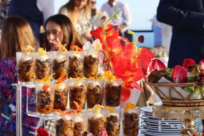 Vue aérienne d'un centre équestre entouré de végétation, avec la mer et des îles en arrière-plan.