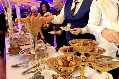 Vue aérienne d'un centre équestre entouré de végétation, avec la mer et des îles en arrière-plan.