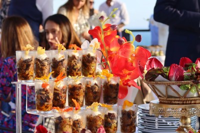 Salle de réception élégamment décorée avec des tables rondes dressées, nappes blanches et centres de table floraux.