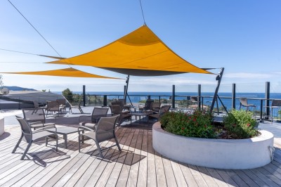 Salle de réception élégamment décorée avec des tables rondes dressées, nappes blanches et centres de table floraux.