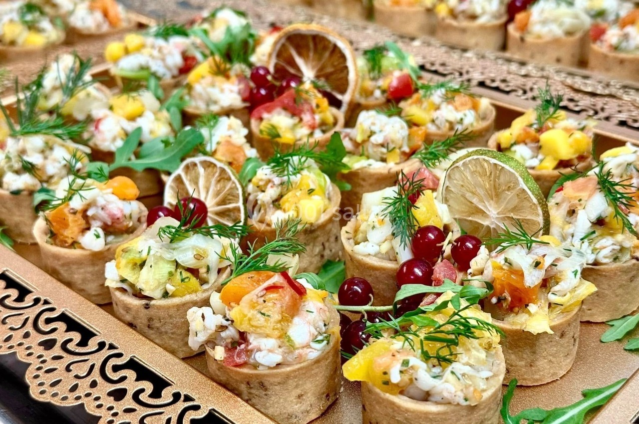 Plateau de bouchées apéritives garnies de fruits, légumes, herbes fraîches et tranches de citron séché.