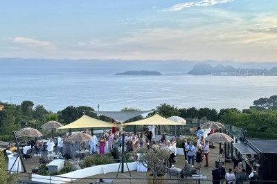 Salle de réception élégamment décorée avec des tables rondes dressées, nappes blanches et centres de table floraux.