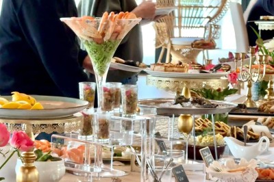 Salle de réception élégamment décorée avec des tables rondes dressées, nappes blanches et centres de table floraux.