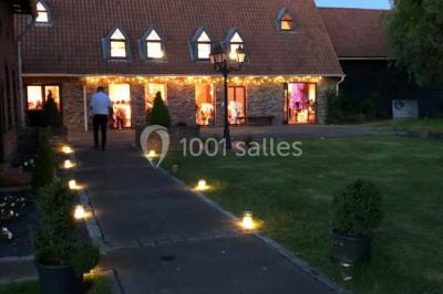 Table élégamment dressée avec menu, couverts, verres et une fleur rouge en centre de table, éclairée par la lumière…