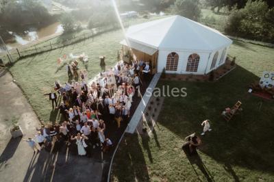 Table élégamment dressée avec menu, couverts, verres et une fleur rouge en centre de table, éclairée par la lumière…