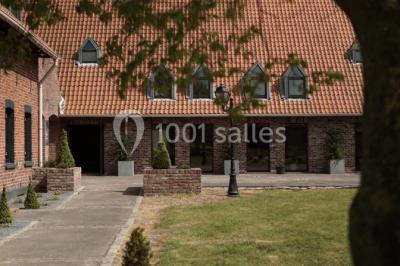 Table élégamment dressée avec menu, couverts, verres et une fleur rouge en centre de table, éclairée par la lumière…