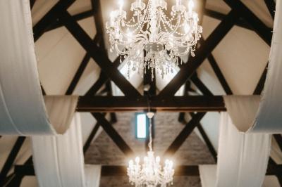 Table élégamment dressée avec menu, couverts, verres et une fleur rouge en centre de table, éclairée par la lumière…