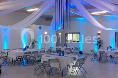 Salle lumineuse avec plafond en bois, grandes baies vitrées, carrelage au sol et chariots de rangement sur roulettes.