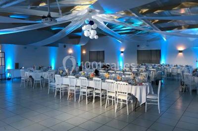 Salle lumineuse avec plafond en bois, grandes baies vitrées, carrelage au sol et chariots de rangement sur roulettes.