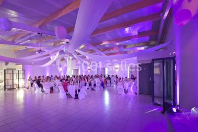 Salle lumineuse avec plafond en bois, grandes baies vitrées, carrelage au sol et chariots de rangement sur roulettes.