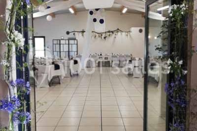 Salle lumineuse avec plafond en bois, grandes baies vitrées, carrelage au sol et chariots de rangement sur roulettes.