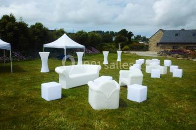 Salle lumineuse avec plafond en bois, grandes baies vitrées, carrelage au sol et chariots de rangement sur roulettes.