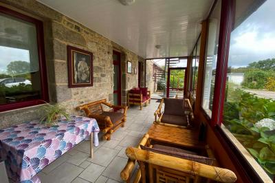 Salle lumineuse avec plafond en bois, grandes baies vitrées, carrelage au sol et chariots de rangement sur roulettes.