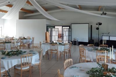 Salle lumineuse avec plafond en bois, grandes baies vitrées, carrelage au sol et chariots de rangement sur roulettes.