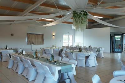 Salle lumineuse avec plafond en bois, grandes baies vitrées, carrelage au sol et chariots de rangement sur roulettes.