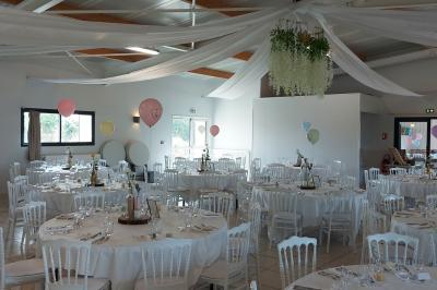 Salle lumineuse avec plafond en bois, grandes baies vitrées, carrelage au sol et chariots de rangement sur roulettes.