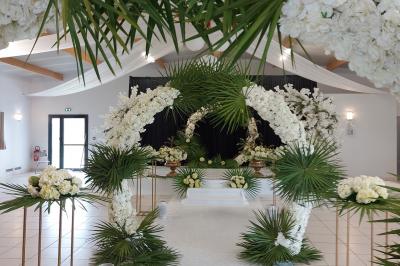 Salle lumineuse avec plafond en bois, grandes baies vitrées, carrelage au sol et chariots de rangement sur roulettes.