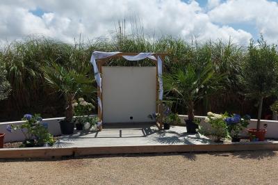 Salle lumineuse avec plafond en bois, grandes baies vitrées, carrelage au sol et chariots de rangement sur roulettes.