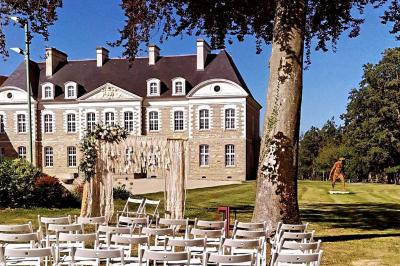 Miniature Location salle Piré-sur-Seiche (Ille-et-Vilaine) - Domaine du Château des Pères #4 Lit double avec une couverture blanche, des coussins colorés et une robe de mariée posée sur le côté.