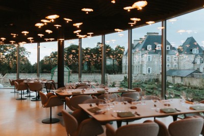 Miniature Location salle Piré-sur-Seiche (Ille-et-Vilaine) - Domaine du Château des Pères #9 Salon moderne avec fauteuils colorés, canapé bleu, tables basses en bois et luminaires suspendus dans un décor chaleureux.