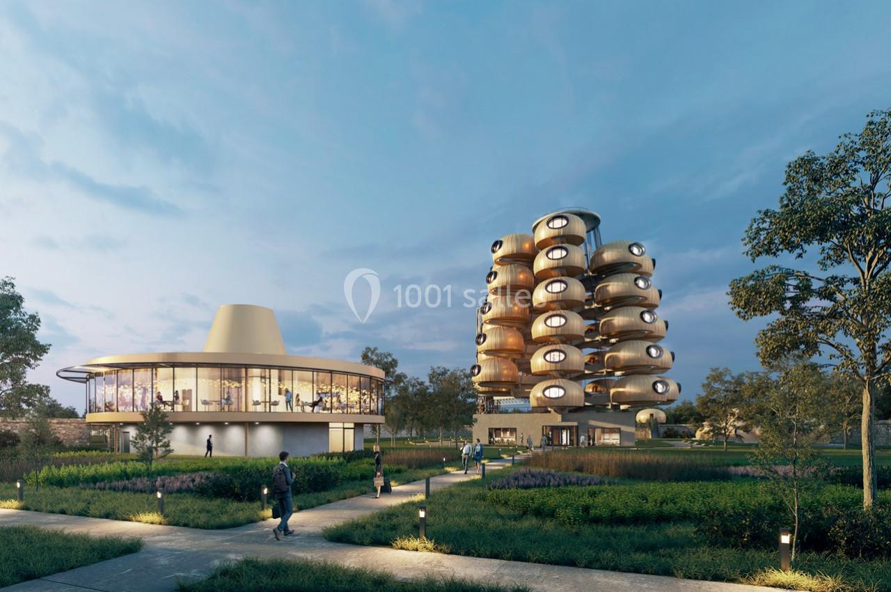 Bâtiments modernes entourés de végétation, avec un ciel dégagé en arrière-plan au crépuscule.