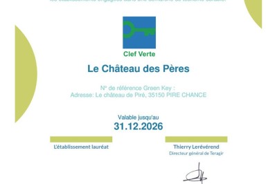 Salle de restaurant chaleureuse avec tables en bois, chaises en rotin, rideaux rouges et éclairage suspendu.