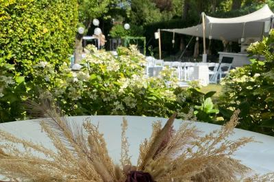 Miniature Location salle Bruxelles (Bruxelles-Capitale) - Villattitude #23 Décoration florale séchée sur une table, avec un jardin verdoyant et une tente blanche en arrière-plan.