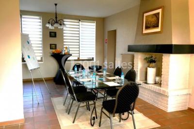 Tente blanche installée sur une pelouse, accueillant un événement avec des invités debout autour de tables hautes.