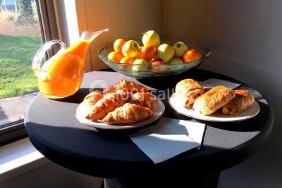 Tente blanche installée sur une pelouse, accueillant un événement avec des invités debout autour de tables hautes.