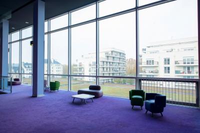 Miniature Location salle Caen (Calvados) - Pathé Les Rives de l'Orne #14 Intérieur d'un bâtiment moderne avec escalier, rambardes en métal, murs colorés et grandes baies vitrées.