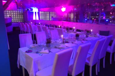 Salle de restaurant lumineuse avec tables dressées, chaises noires et blanches, et terrasse extérieure avec vue sur des…